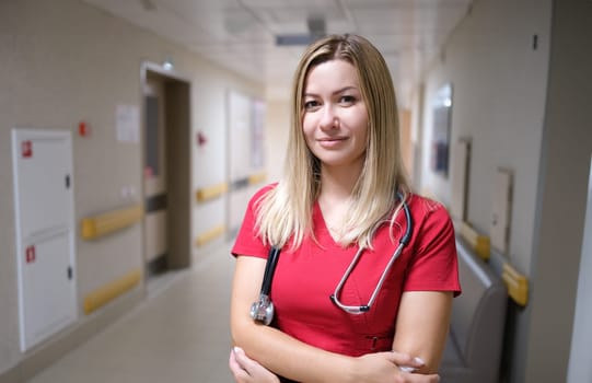 Young and attractive doctor on background of hospital corridor. Medical care concept