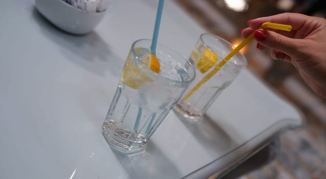 Woman squeezes lemon juice into glass. Fasting lemon water concept