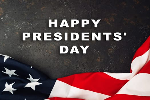 A red and white American flag with the words Happy Presidents' Day written below it. The flag is draped over a dark background, creating a sense of patriotism and celebration