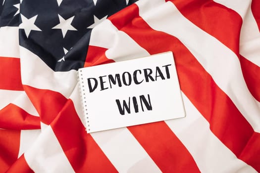 A red and white American flag with a white piece of paper that says Democrat win