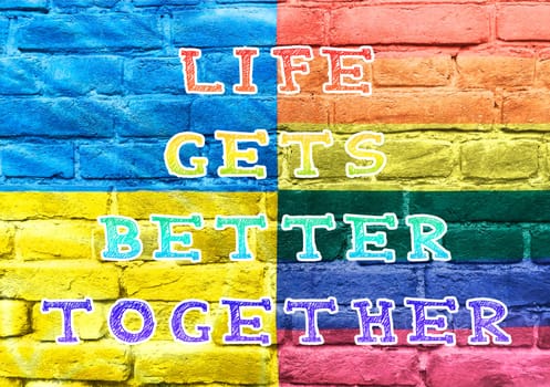 A colorful sign that says Life gets better together. The sign is made up of different colors and is placed on a brick wall