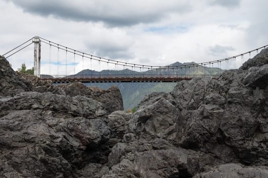 Fast mountain river Katun and Oroctoy bridge in Altay, Siberia, Russia.