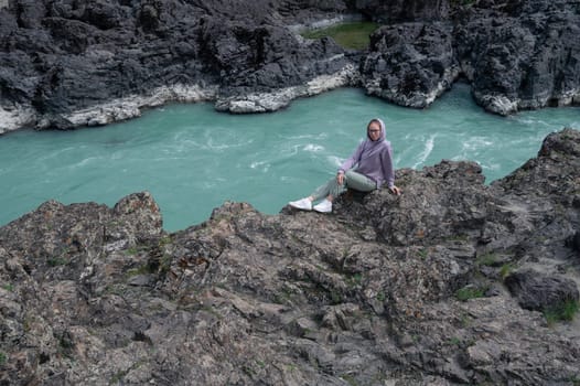 Woman at the river Katun at summer day. Trip on Altai Mountains in Altai Republic