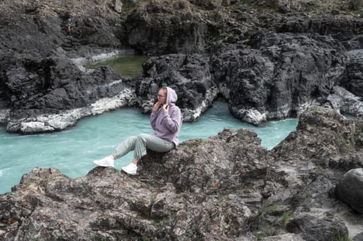 Woman at the river Katun at summer day. Trip on Altai Mountains in Altai Republic