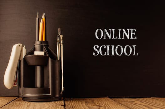 A black desk with a pencil holder and a pen holder. The image is titled Online School