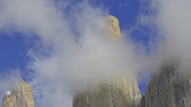 Captivating video shows Torres del Paine's snowy peaks amidst floating clouds.