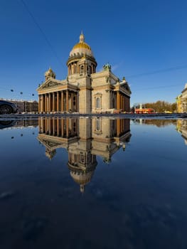 incredible reflection in spring puddles of St. Isaac's Cathedral in St. Petersburg - Russia at sunny eather. High quality photo