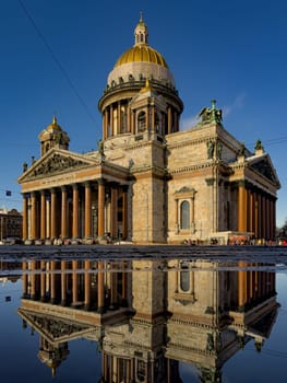 incredible reflection in spring puddles of St. Isaac's Cathedral in St. Petersburg - Russia at sunny eather. High quality photo