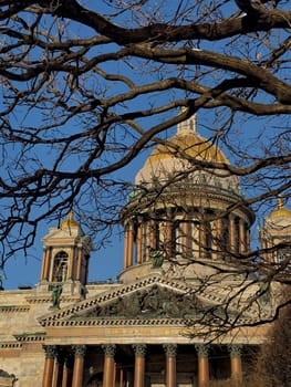 front of St. Isaac's Cathedral through branches of trees in St. Petersburg - Russia in the spring sun. High quality photo