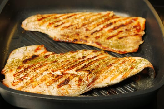 Grilled salmon fillets sizzle and sear on the grill, releasing mouthwatering aromas.