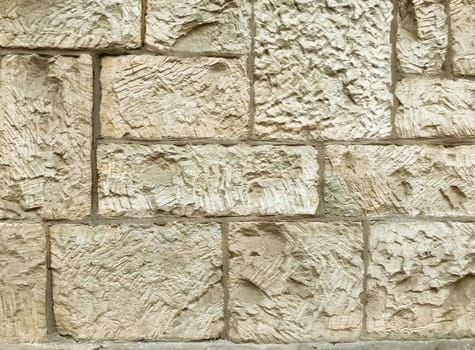 A wall made of stone with a rough texture. The wall is white and has a stone-like appearance