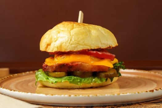 Cheeseburger topped with fresh lettuce and tomato on a sesame seed bun, ready to be enjoyed.