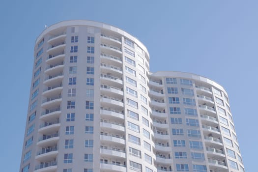 Burgas, Bulgaria - March 23, 2024: Modern high-rise residential building with curved balconies against a blue sky