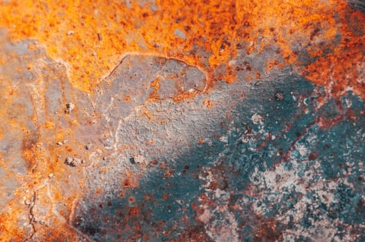 The image is of a rusty surface with a blue and orange color scheme. The surface appears to be old and worn, with a lot of rust and dirt. The colors of the surface create a mood of decay