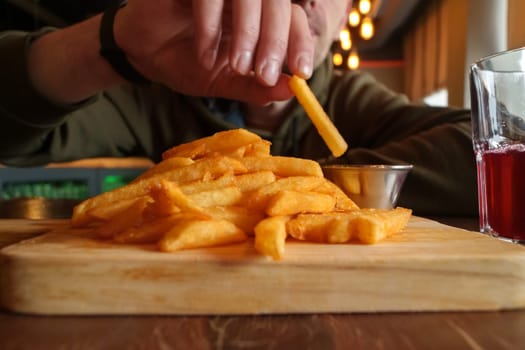 Crispy French fries arranged neatly on a wooden cutting board, showcasing their golden color and crispy texture.