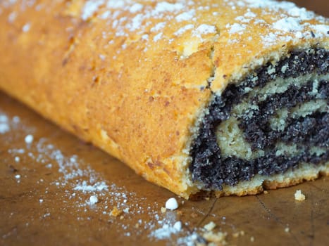 close-up of poppy seed roll sprinkled with powdered sugar.