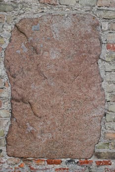 Old fortress wall of red brick interspersed with large cobblestones