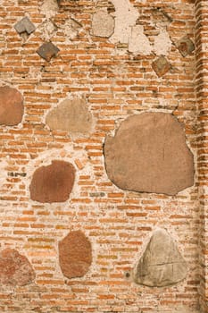 Medieval wall made of bricks and stone. Abstract background.