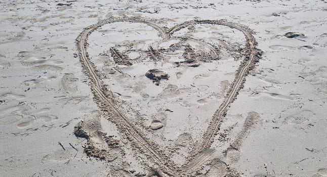 Heart shape drawn in the sand of the beach