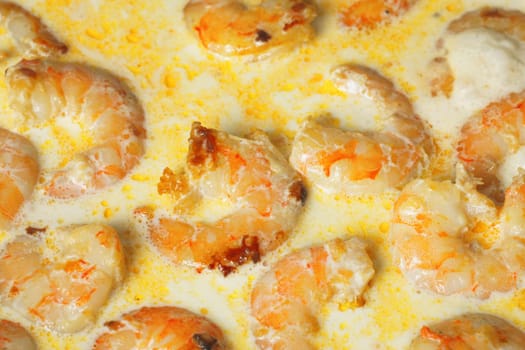 Succulent shrimp bathed in a creamy garlic sauce, with a golden hue indicating a lightly toasted surface.