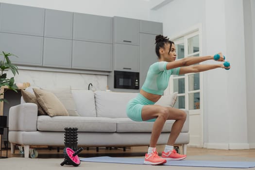 Training to become the best. Beautiful young woman in sports clothing exercising at home.