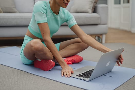 Training to become the best. Beautiful young woman in sports clothing exercising at home.