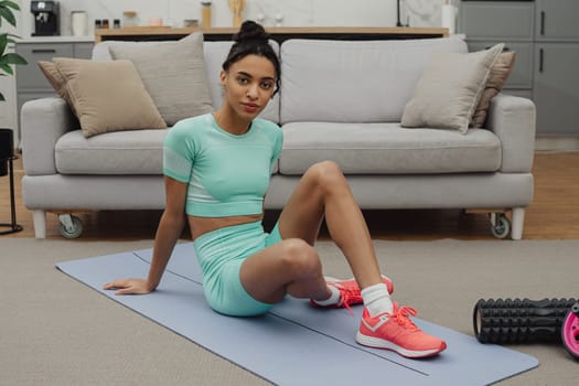 Training to become the best. Beautiful young woman in sports clothing exercising at home.