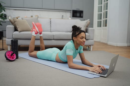 Training to become the best. Beautiful young woman in sports clothing exercising at home.