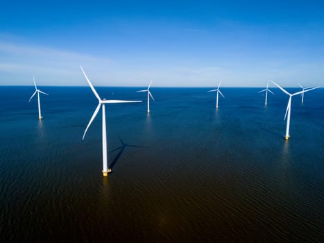 A group of wind turbines stand tall in the ocean, harnessing the power of the wind to generate renewable energy in the Netherlands Flevoland during the vibrant season of Spring.