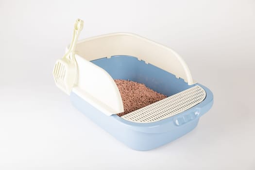 Isolated on a white background a plastic cat litter toilet tray with scoop is a hygiene and care essential for your furry friend's litter box.