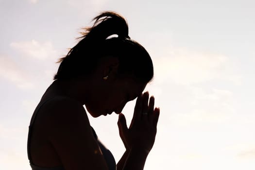 backlight portrait of young asian woman practicing yoga in pray position, concept of mental relaxation and healthy lifestyle, copy space for text