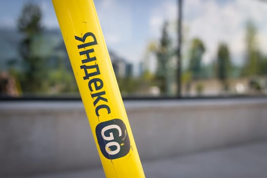 Close-up of the Yandex Go logo on a yellow electric scooter. Almaty, Kazakhstan - June 05, 2023