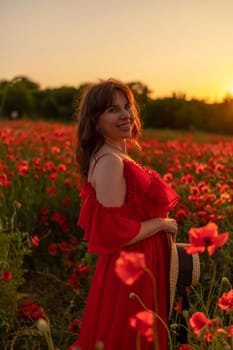 Woman poppy field red dress sunset. Happy woman in a long red dress in a beautiful large poppy field. Blond stands with her back posing on a large field of red poppies.