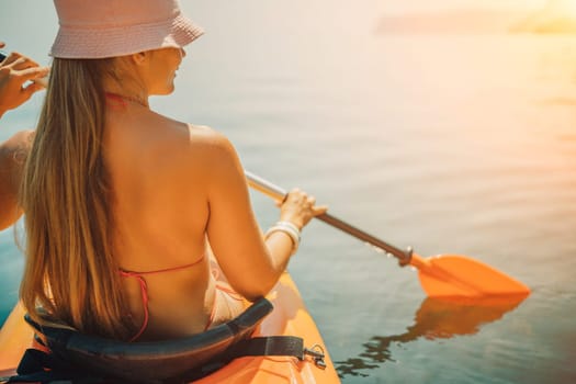 woman bikini paddles kayak on a lake. The sun is shining brightly, creating a warm and inviting atmosphere