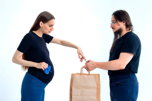 Portrait happy young pregnant woman and her husband with shopping bags and touching her big belly isolated on white background. Pregnancy shopping concept happy young family with shopping bags