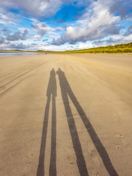 Shadow of couple enjoying the beach.