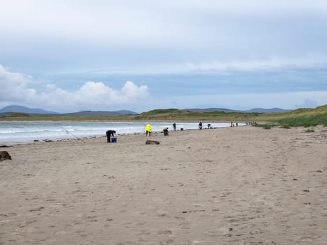 20 man are competing in a fishing competition on the beach