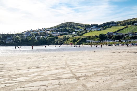 DOWNINGS, IRELAND - JULY 31 2022: Holiday makers enjoying the beach.