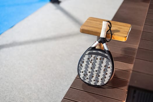 Paddle tennis: Paddel racket and ball in front of an outdoor court. High quality photo