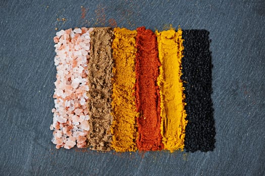 Row, spice and collection of powder for seasoning, turmeric and paprika for meal. Top view, condiments and options for spicy cooking in Indian culture, cumin and food preparation on table for aroma.