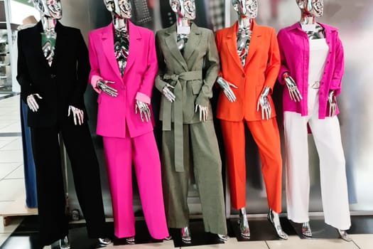 Colorful women's clothing in a boutique is worn on mannequins.