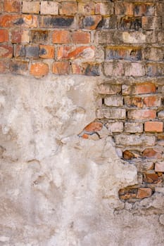 Detailed closeup texture and full-frame background of a brick wall with plaster leftovers.
