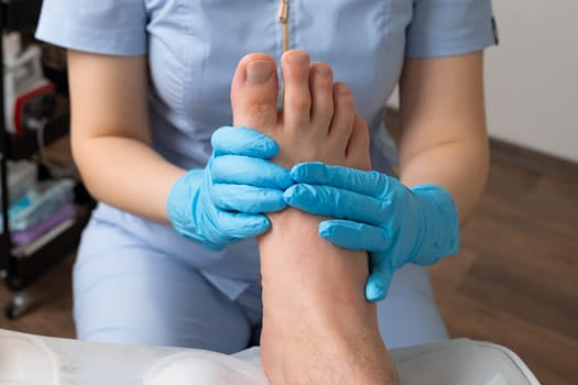 Man having foot massage from professional masseur in the clinic.