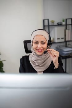 Young muslim women wearing hijab telemarketing or call center agent with headset working on support hotline at office.