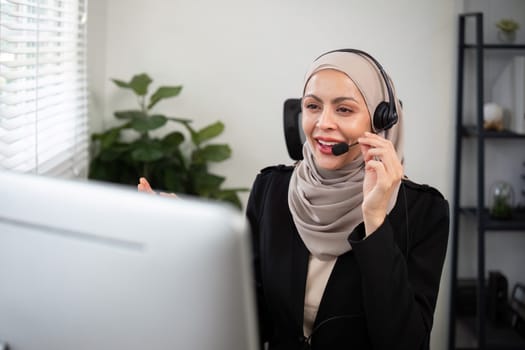 Young muslim women wearing hijab telemarketing or call center agent with headset working on support hotline at office.