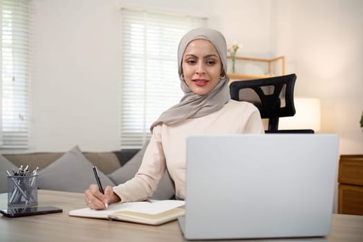 Portrait asian muslim woman manager working with laptop computer at home.