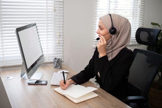Young muslim women wearing hijab telemarketing or call center agent with headset working on support hotline at office.
