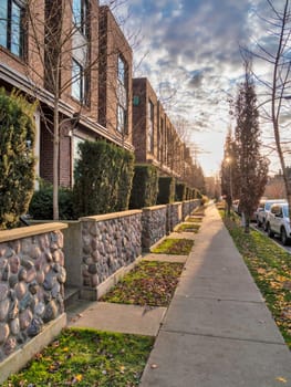 Sidewalk along townhouses on autumn season in Queensborough residential community.