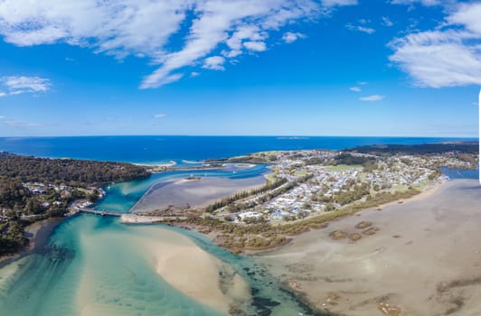 Aerial view of the idyllic coastal town of Narooma wrapped around the famous Wagonga Inlet in South Coast, New South Wales, Australia