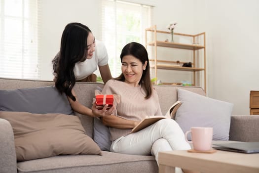 Happy mother day. Beautiful young daughter woman and mother with gift box at home.